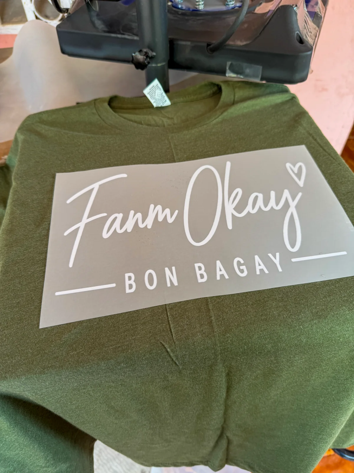 Préparation du transfert Fanm Okay sur un T-shirt vert